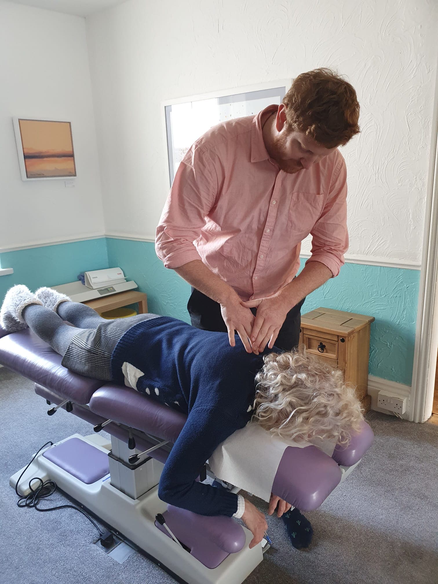 Will Tucker giving a gentle hands-on adjustment to an elderly guest in the Vibrant Life clinic
