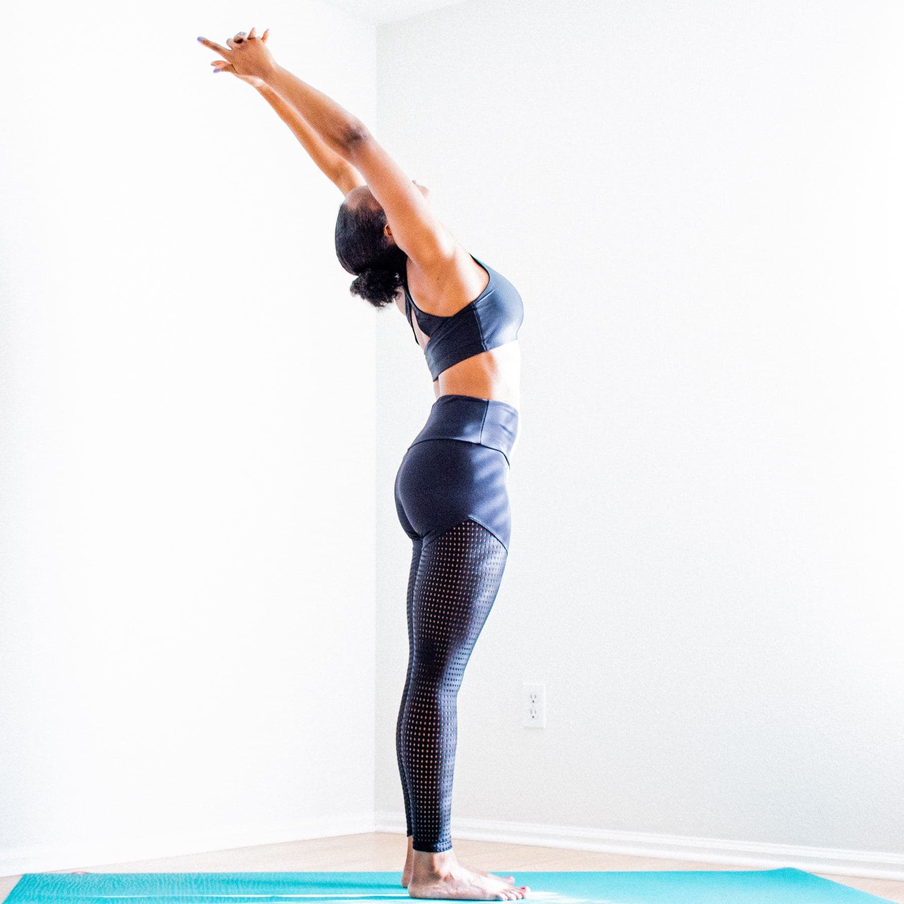 Woman in yoga stretch with arms reaching upward — daily movement practice